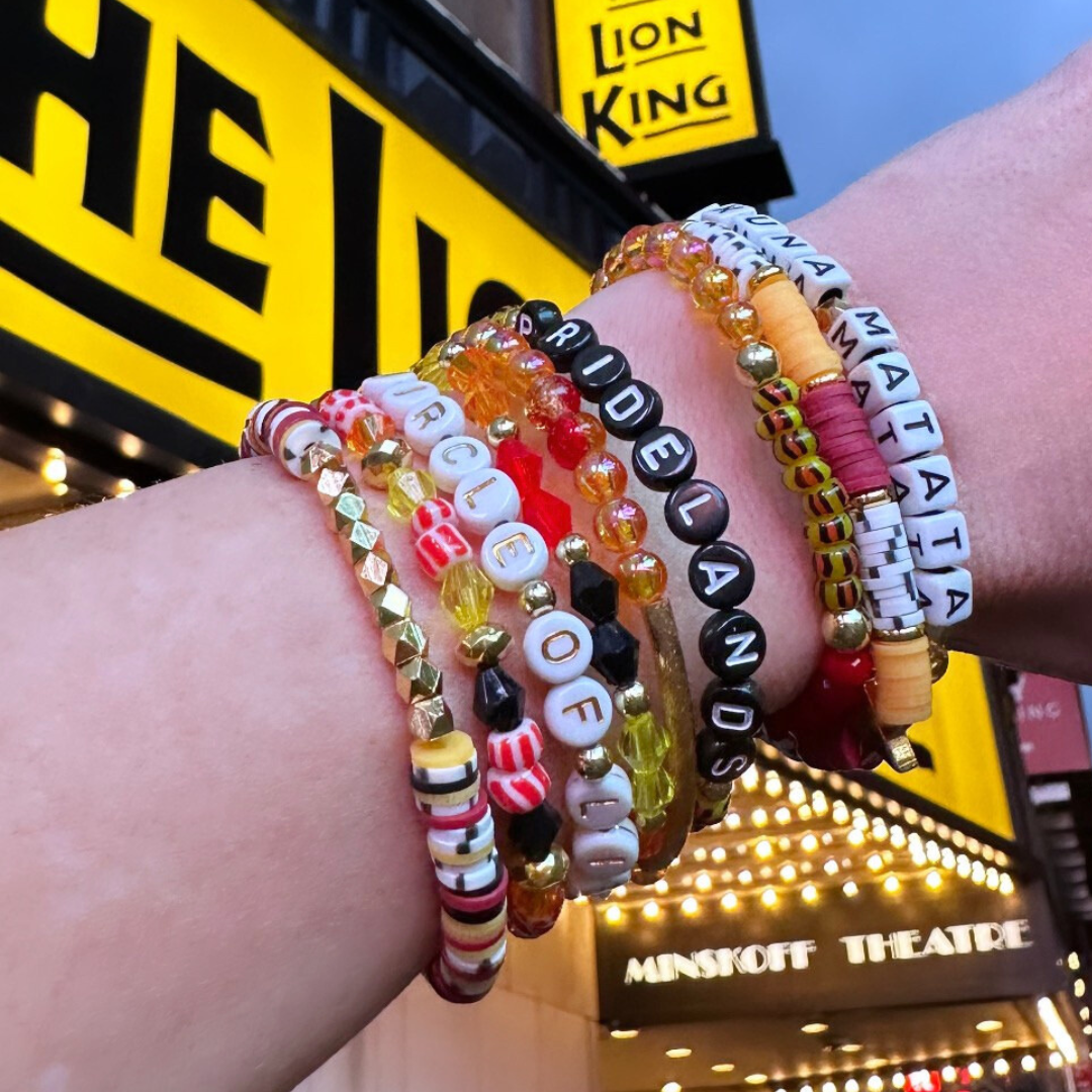 Broadway Stacks SAFARI collection. Dark reds, yellow, orange, white, black and gold colored beads. Animal print beads as well. Letter beads that spell quotes, Gold star logo bead to remind you that you shine.
