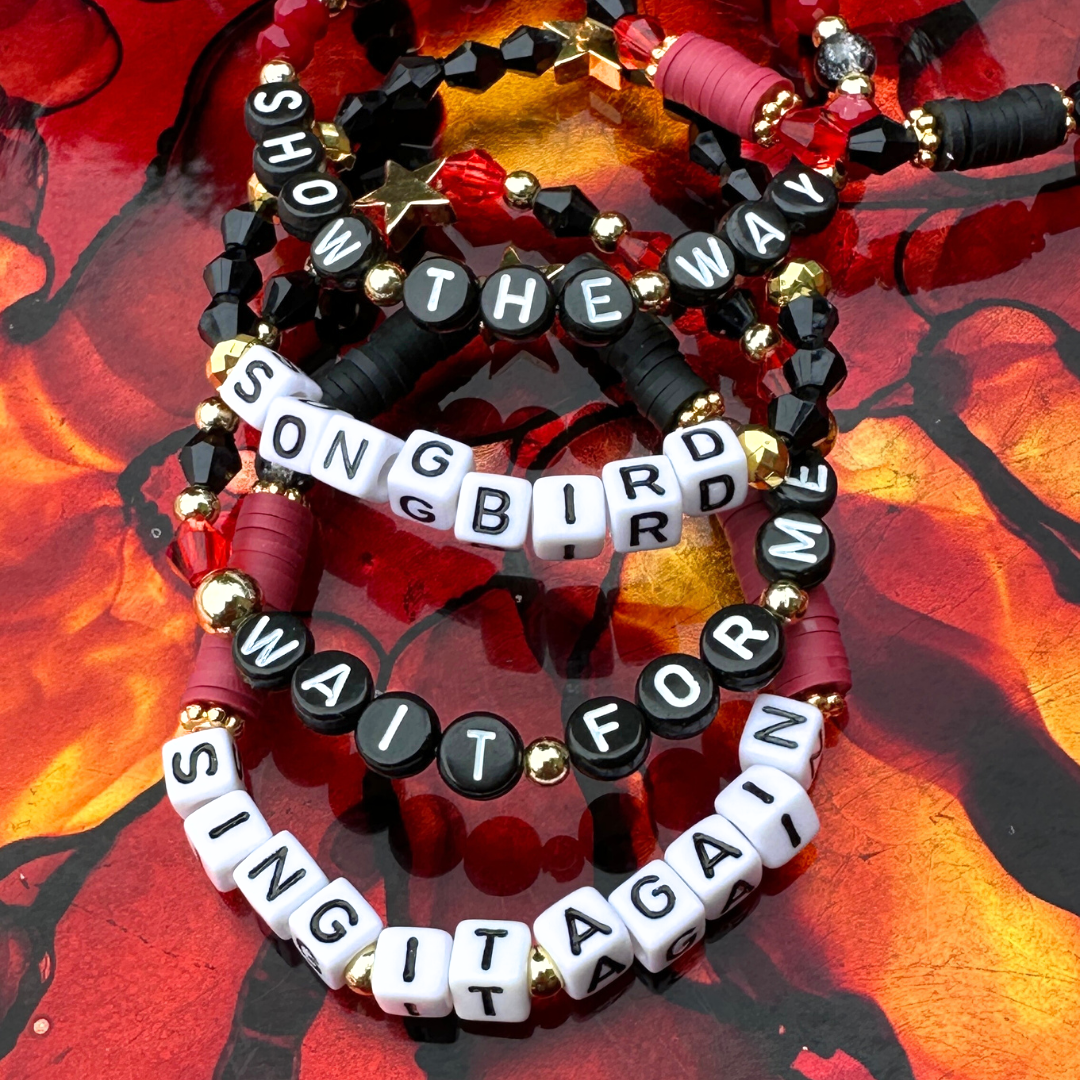 Broadway Stacks UNDERWORLD collection. 5 stretch bracelets included in Stack. Red, garnet, black and gold colored beads. Letter beads that spell quotes. Gold star logo bead to remind you that you shine. Hadestown fans.