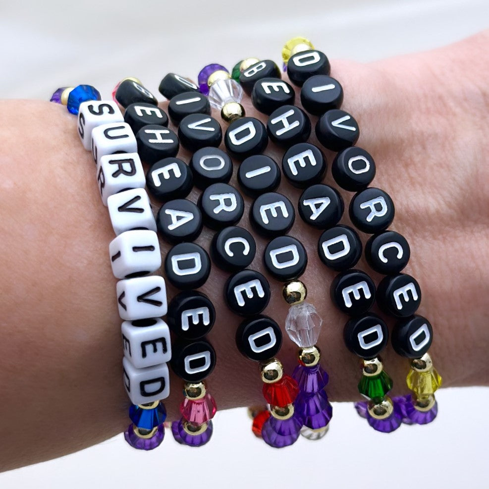 Broadway Stacks HerStory Stack. 6 Stretch bracelets included in Stack. Divorced, beheaded, died, divorced, beheaded, survived. Gold, yellow, green, white, red, pink and blue colored beads. Broadway Stacks gold star logo bead on back.