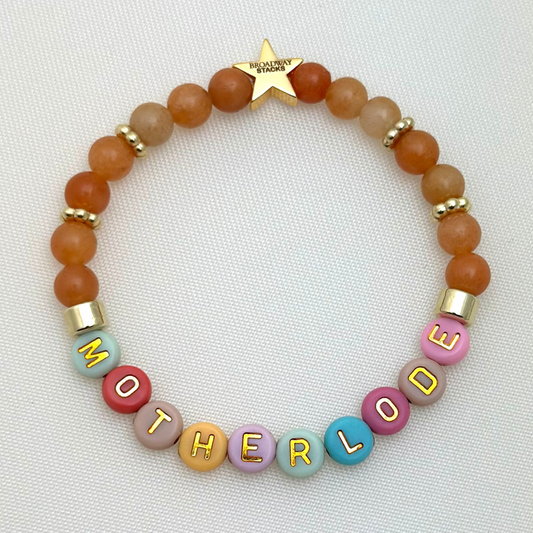 Broadway Stacks Motherlode Special Edition bracelets. Stretch bracelets. Greens, browns, white and gold colored beads. Letter beads that spell Motherlode, Boy Mom, Girl Mom, Twin Mom,
