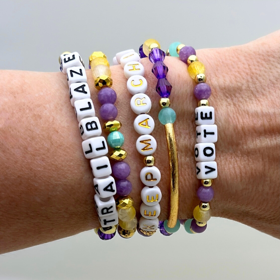 Suffs musical bead bracelets, purple, yellow, teal and gold beads, gold star logo bead of Broadway Stacks