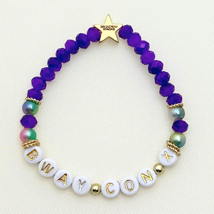 Broadway Stacks BroadwayCon X 2025 Special Edition bracelet. 1 stretch bracelet. Purple, gold and iridescent colored beads. Letter beads that spell Bway Con X.