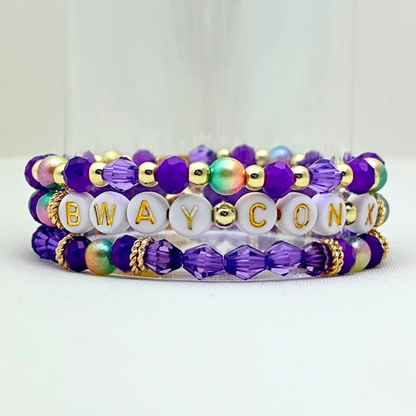 Broadway Stacks BroadwayCon X 2025 Special Edition bracelet. Stack of 3 bracelets. Purple, gold and iridescent colored beads. Letter beads that spell Bway Con X.