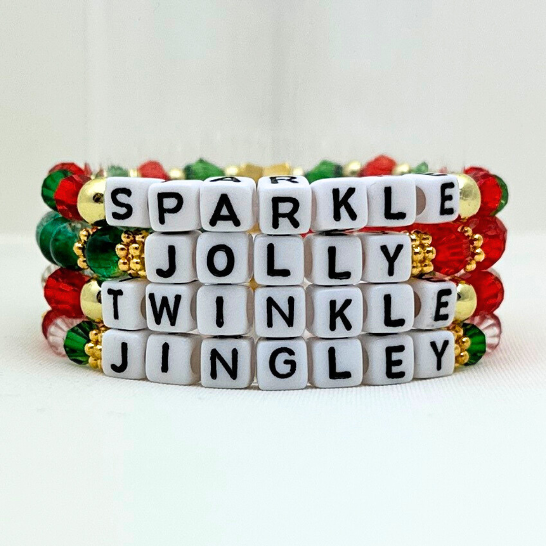 Broadway Stacks CHRISTMAS Collection. 4 stretch bracelets included in Stack. Red, green, white and gold colored beads. Letter beads that spell quotes. Gold star logo bead to remind you that you shine.