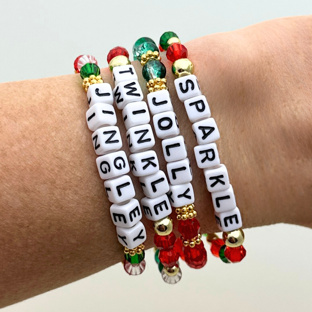 Broadway Stacks CHRISTMAS Collection. 4 stretch bracelets included in Stack. Red, green, white and gold colored beads. Letter beads that spell quotes. Gold star logo bead to remind you that you shine.