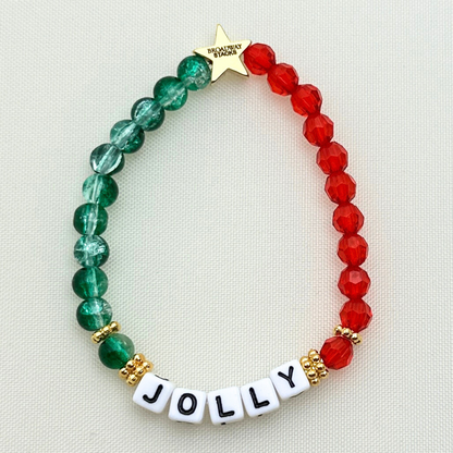 Broadway Stacks CHRISTMAS Collection. 4 stretch bracelets included in Stack. Red, green, white and gold colored beads. Letter beads that spell quotes. Gold star logo bead to remind you that you shine.