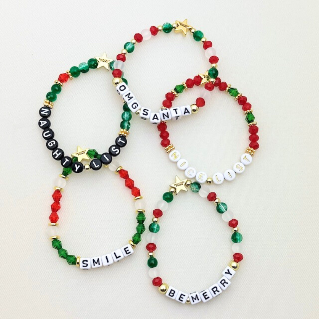 Broadway Stacks CHRISTMAS Collection. 5 stretch bracelets included in Stack. Red, green, white and gold colored beads. Letter beads that spell quotes. Gold star logo bead to remind you that you shine.