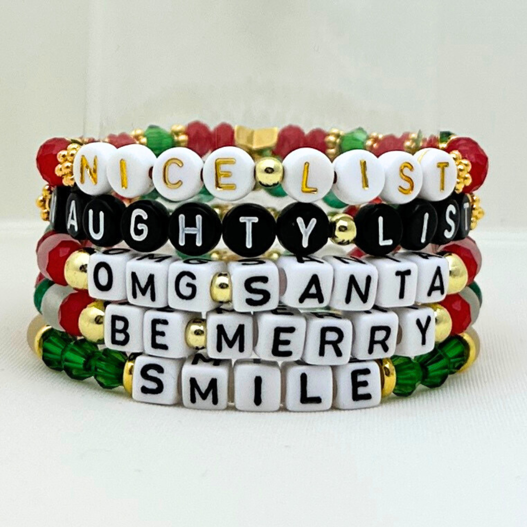 Broadway Stacks CHRISTMAS Collection. 5 stretch bracelets included in Stack. Red, green, white and gold colored beads. Letter beads that spell quotes. Gold star logo bead to remind you that you shine.