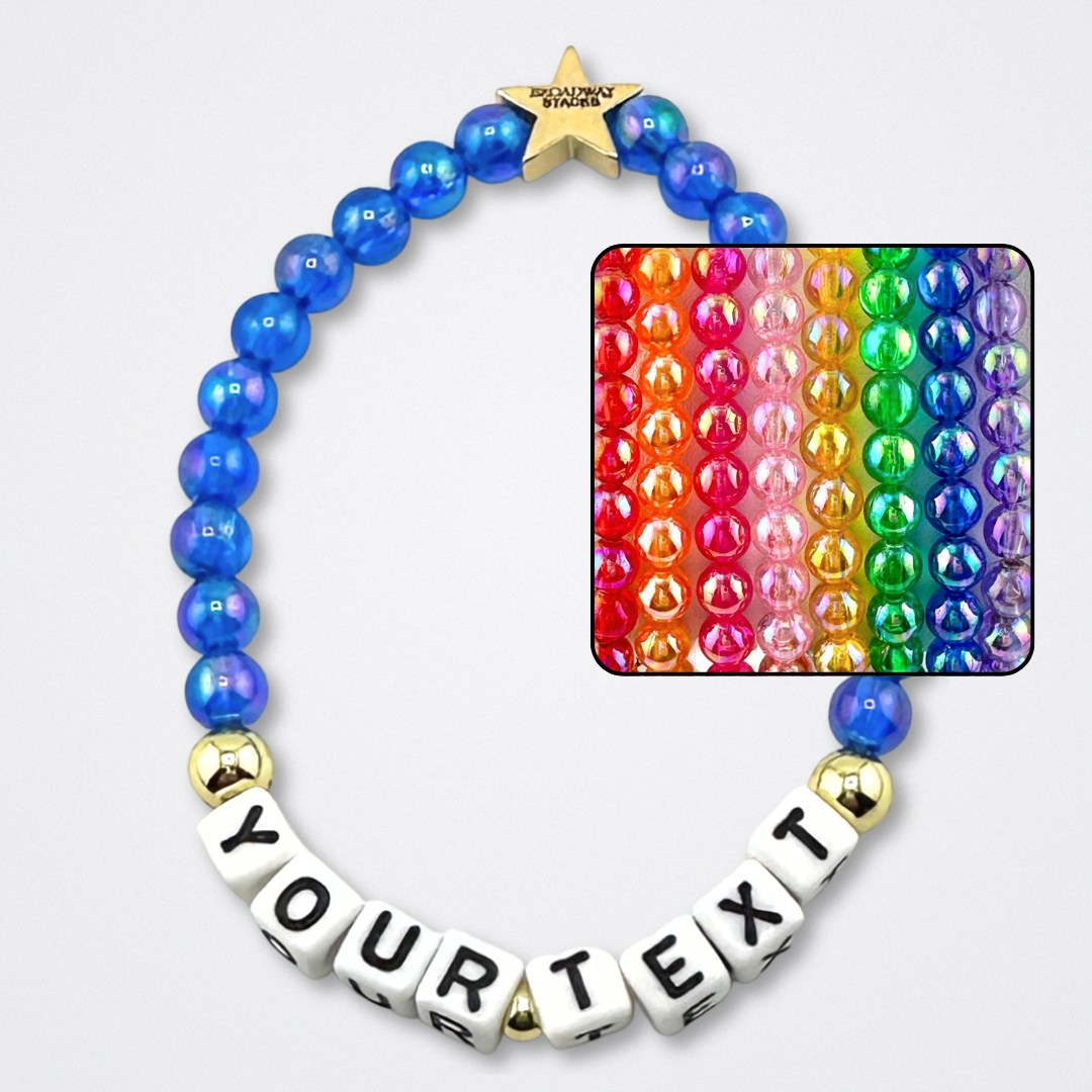 Broadway Stacks rainbow colors elastic stretch bracelets with gold color accents. Letter beads spell out YOUR TEXT, for custom bracelet. Gold star logo bead to remind you that You Shine. Available in 8 different colors. Displayed on a gray background.