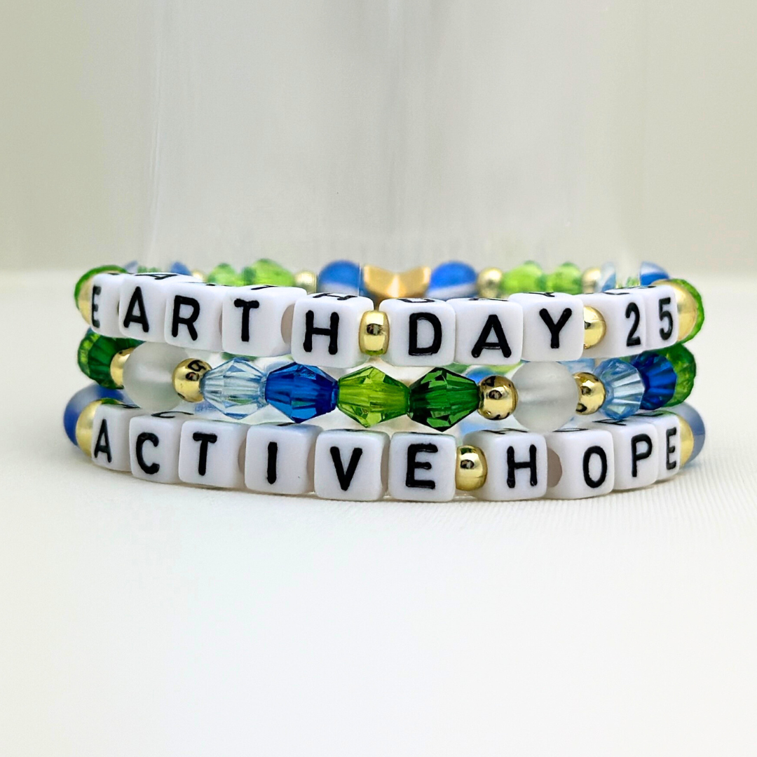 Earth Day 2025 Special Edition bracelet. Stack of 3 bracelets. Green, blue, white and gold beads. Letter beads that spell Earth Day 25 and Active Hope. Gold star logo bead to remind you that you shine.