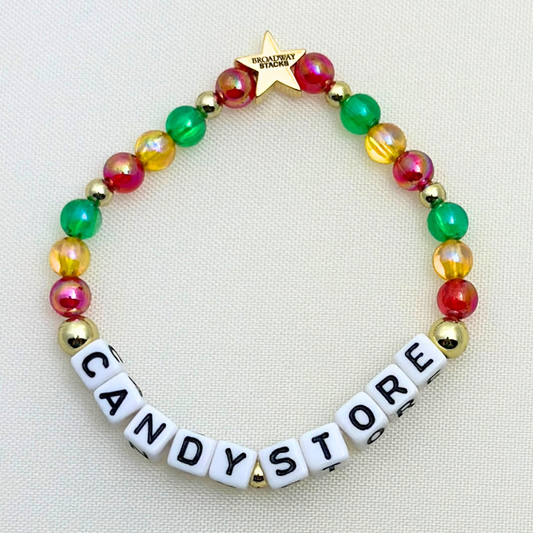 Broadway Stacks CORN NUTS Collection. 5 stretch bracelets included in Stack. Red, yellow, green, blue, black and gold colored beads. Letter beads that spell quotes. Gold star logo bead to remind you that you shine. Heathers the Musical fans.