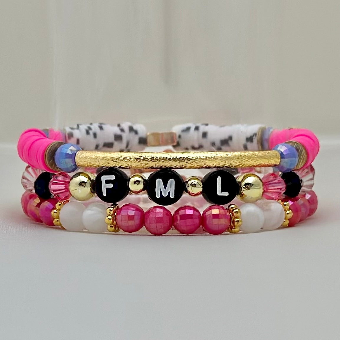 Broadway Stacks POTUS collection. 3 stretch bracelets included in Stack. Pinks, white, blue, golds and black colored beads. Letter beads that spell show quotes. Broadway Stacks gold star logo bead on back.