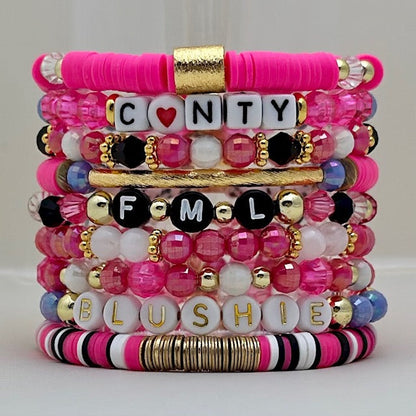 Broadway Stacks POTUS collection. 3 stretch bracelets included in Stack. Pinks, white, blue, golds and black colored beads. Letter beads that spell show quotes. Broadway Stacks gold star logo bead on back.