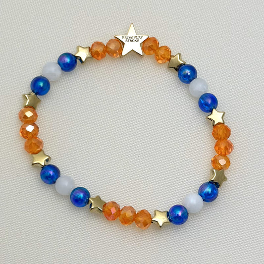 Broadway Stacks BroadwayCon 2024 Star To Be bracelet. 1 stretch bracelet. Blue, orange, white and gold colored beads with star logo bead.