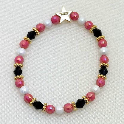 Broadway Stacks POTUS collection. 3 stretch bracelets included in Stack. Pinks, white, blue, golds and black colored beads. Letter beads that spell show quotes. Broadway Stacks gold star logo bead on back.