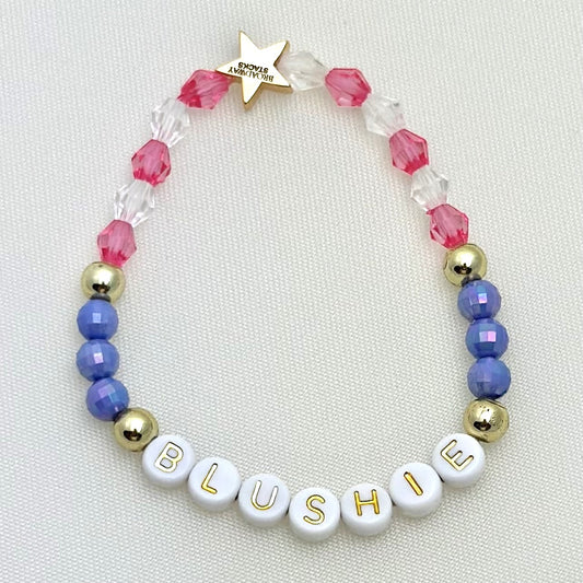 Broadway Stacks POTUS collection. 3 stretch bracelets included in Stack. Pinks, white, blue, golds and black colored beads. Letter beads that spell show quotes. Broadway Stacks gold star logo bead on back.