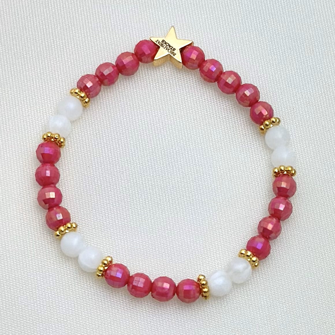 Broadway Stacks POTUS collection. 3 stretch bracelets included in Stack. Pinks, white, blue, golds and black colored beads. Letter beads that spell show quotes. Broadway Stacks gold star logo bead on back.