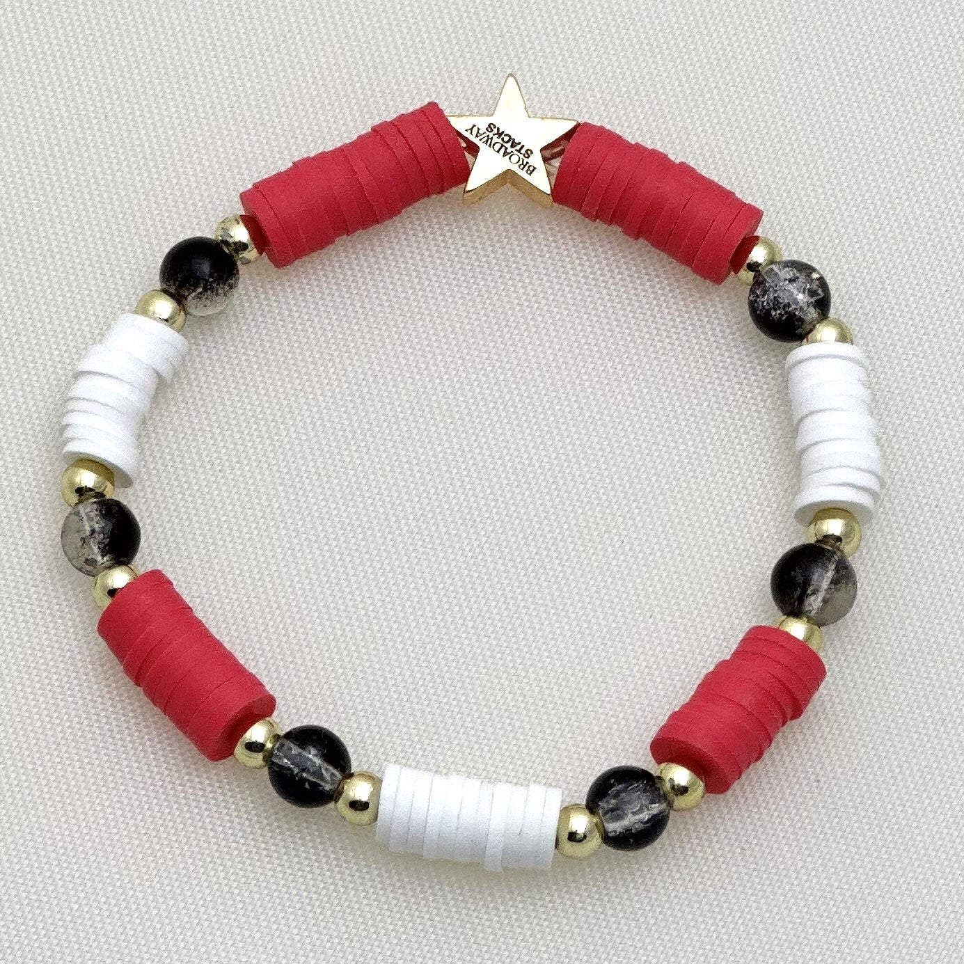 Broadway Stacks Phantom collection. 3 stretch bracelets included in Stack. Red, black, white and gold colored beads. Letter beads that spell Angel Of Music.