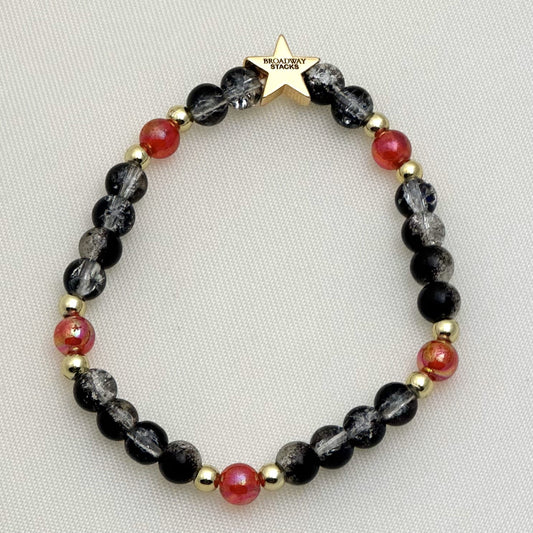 Broadway Stacks MASK collection. 3 stretch bracelets included in Stack. Red, white, gold and black colored beads. Letter beads that spell show quotes. Broadway Stacks gold star logo bead on back.