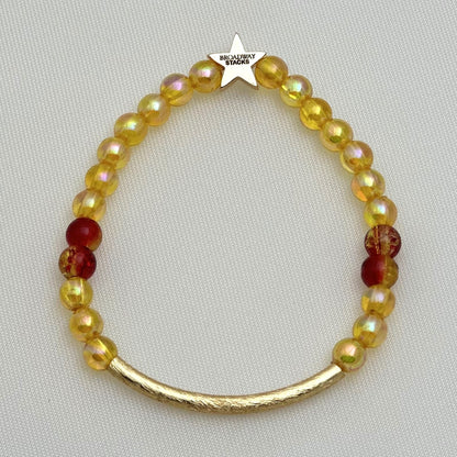 Broadway Stacks SAFARI collection. 3 stretch bracelets included in Stack. Reds, oranges, yellows, black, gold and animal print colored beads. Letter beads that spell show quotes. Broadway Stacks gold star logo bead on back.