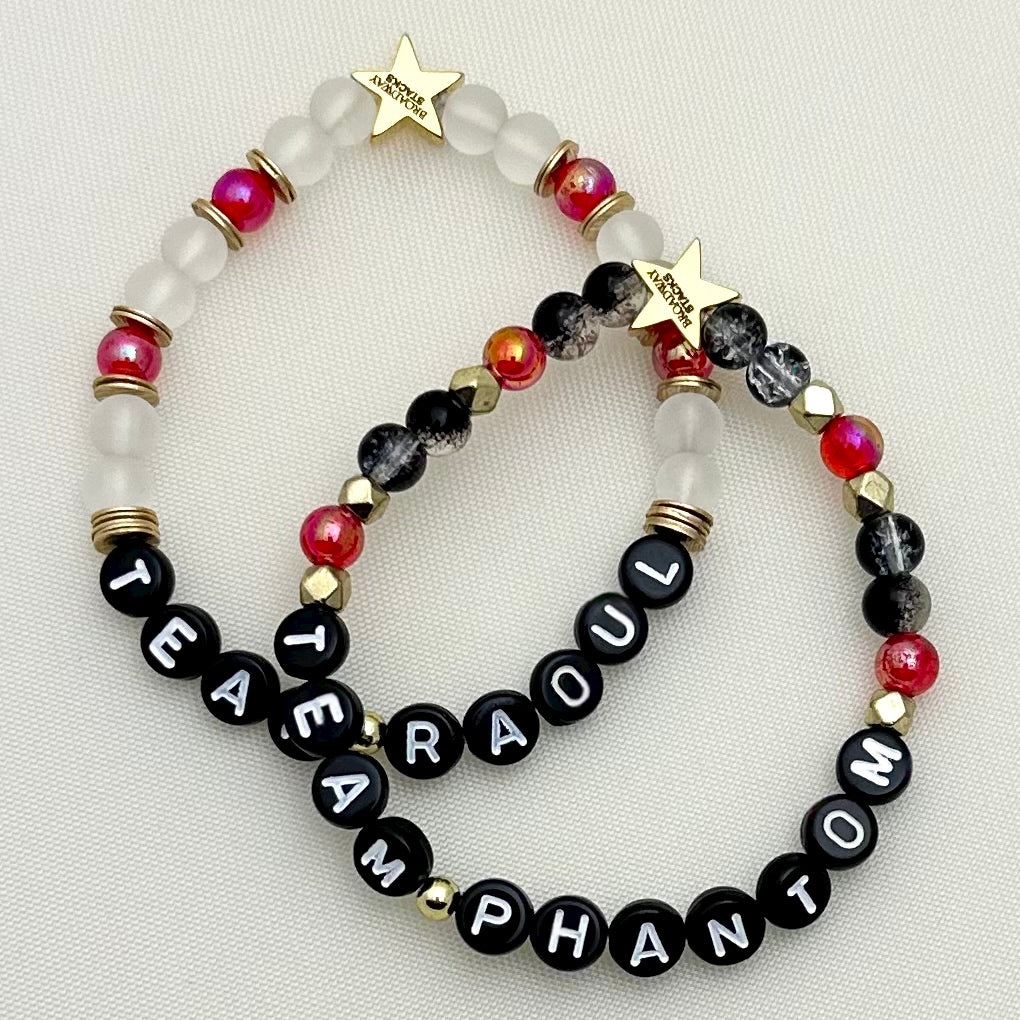 Broadway Stacks MASK collection. Stretch bracelet with red, black, gold and letter beads. Gold star logo bead.