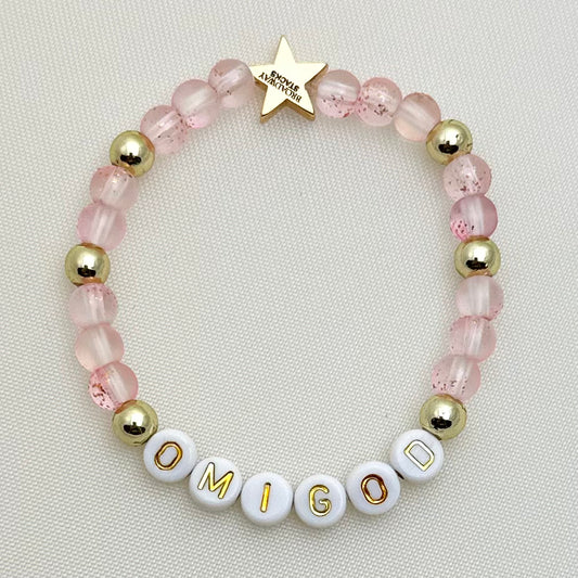 Broadway Stacks KEEP IT POSITIVE collection. 3 stretch bracelets included in Stack. Pinks, white, and gold colored beads. Letter beads that spell show quotes. Broadway Stacks gold star logo bead on back.