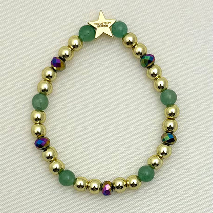 Broadway Stacks STAY GOLD collection. Stretch bracelets included in Stack. Gold, yellow, green and grey colored beads. Letter beads that have show quote or name. Broadway Stacks gold star logo bead on back.