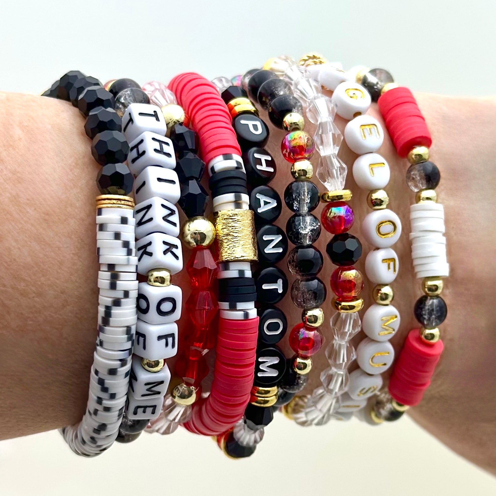 Broadway Stacks Phantom collection. 3 stretch bracelets included in Stack. Red, black, white and gold colored beads. Letter beads that spell Phantom.