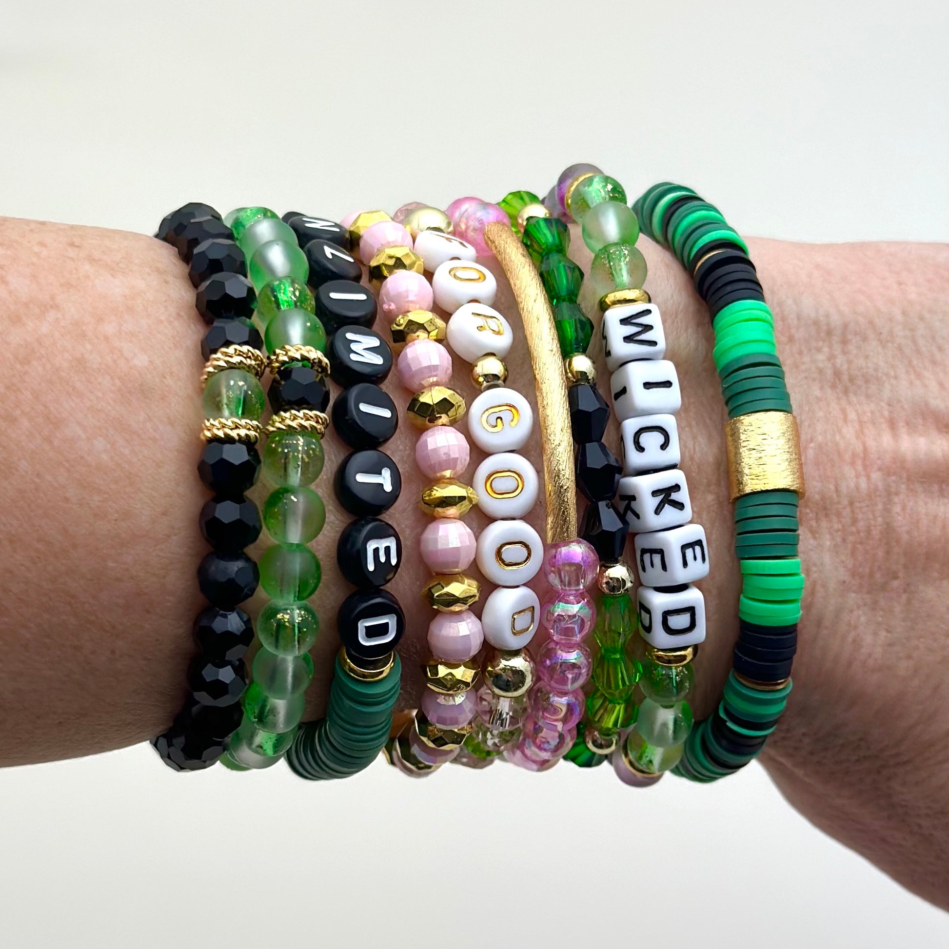 Broadway Stacks Witch collection. 3 stretch bracelets included in Stack. Greens, pinks, black and gold colored beads. Letter beads that spell Wicked.