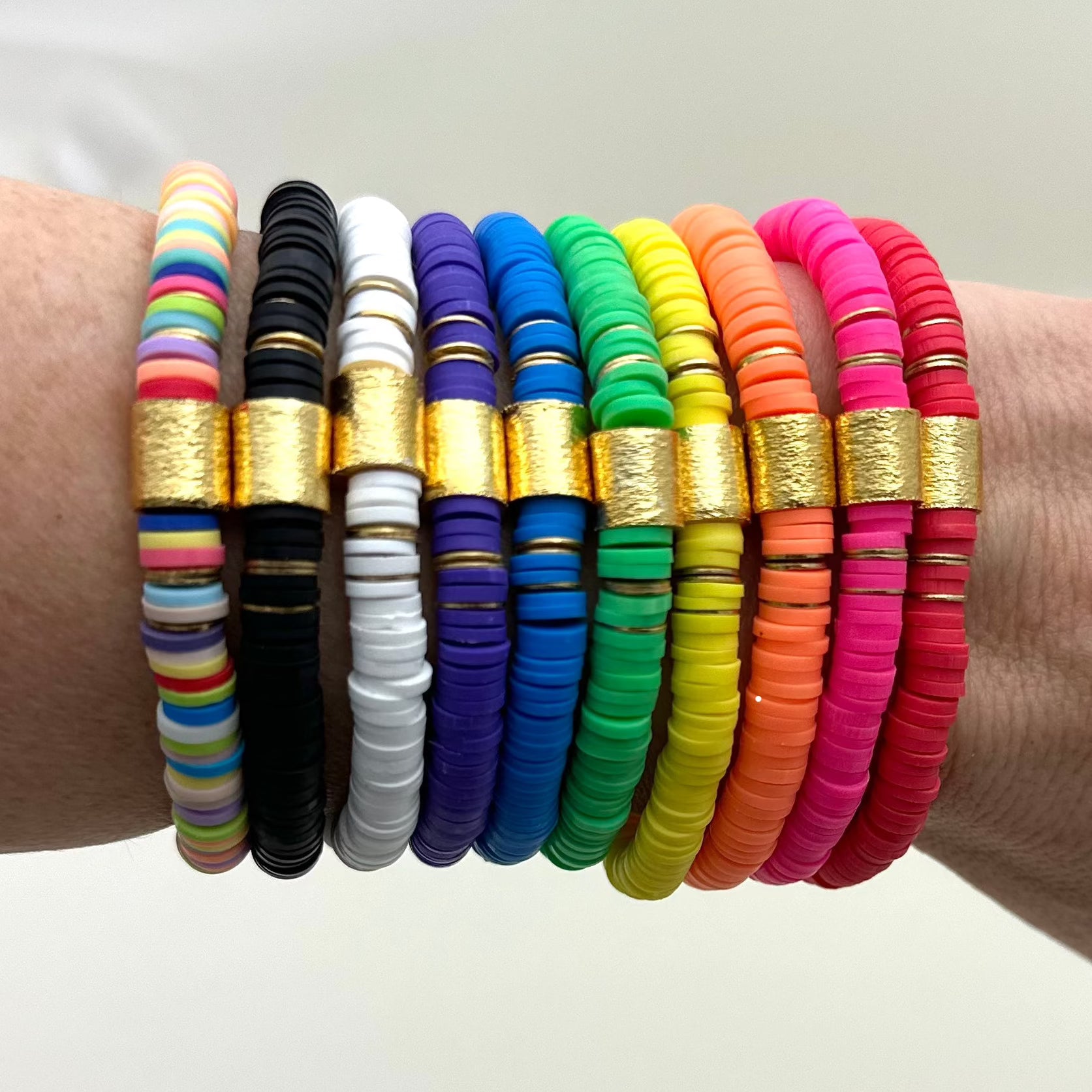 Broadway Stacks rainbow colors elastic stretch bracelets with gold color accents. Gold star logo bead that says Broadway Stacks. Available in red pink orange yellow green blue purple white black and mulit-color.