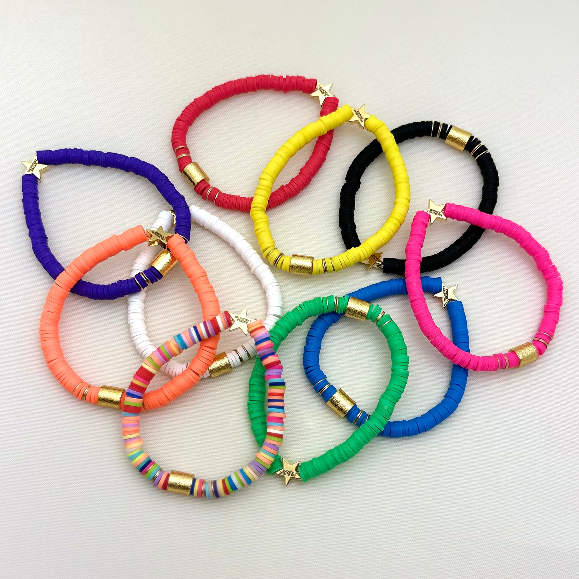 Broadway Stacks rainbow colors elastic stretch bracelets with gold color accents. Gold star logo bead that says Broadway Stacks. Available in red pink orange yellow green blue purple white black and mulit-color.