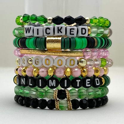 Broadway Stacks Witch collection. 3 stretch bracelets included in Stack. Greens, pinks, black and gold colored beads. Letter beads that spell Wicked.