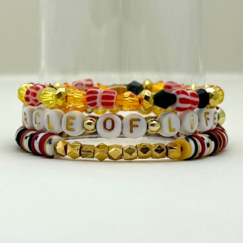 Broadway Stacks SAFARI collection. 3 stretch bracelets included in Stack. Dark reds, yellow, orange, white, black and gold colored beads. Animal print beads as well. Letter beads that spell Circle of Life.