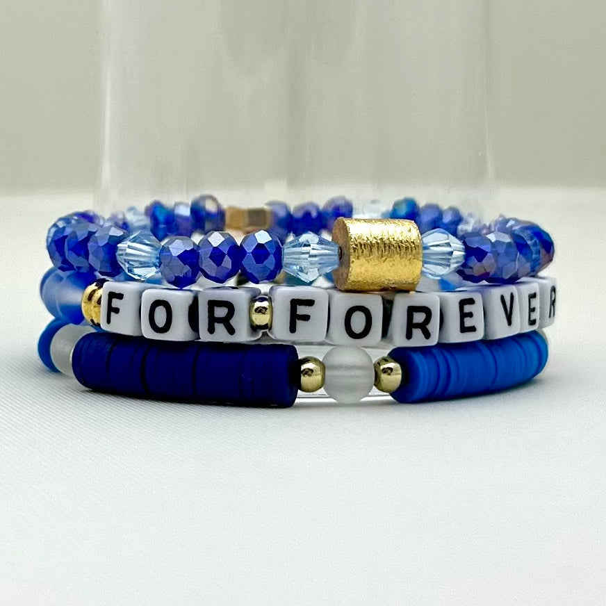 Broadway Stacks SKY collection. 3 stretch bracelets included in Stack. Blues, white, clear, gold and black colored beads. Letter beads that spell show quotes. Broadway Stacks gold star logo bead on back.