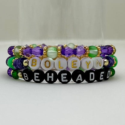 Broadway Stacks QUEEN collection. Stretch bracelets included in Stack. Gold, yellow, green, white, red, pink and blue colored beads. Letter beads that spell each queen. Also Herstory collection. Broadway Stacks gold star logo bead on back.