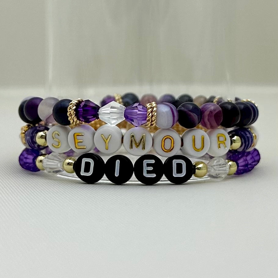 Broadway Stacks QUEEN collection. Stretch bracelets included in Stack. Gold, yellow, green, white, red, pink and blue colored beads. Letter beads that spell each queen. Also Herstory collection. Broadway Stacks gold star logo bead on back.