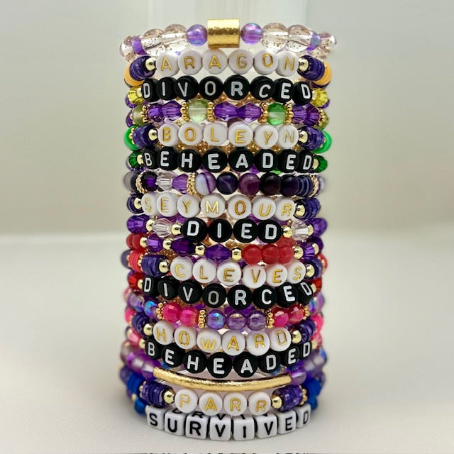 Broadway Stacks QUEEN collection. Stretch bracelets included in Stack. Gold, yellow, green, white, red, pink and blue colored beads. Letter beads that spell each queen. Also Herstory collection. Broadway Stacks gold star logo bead on back.