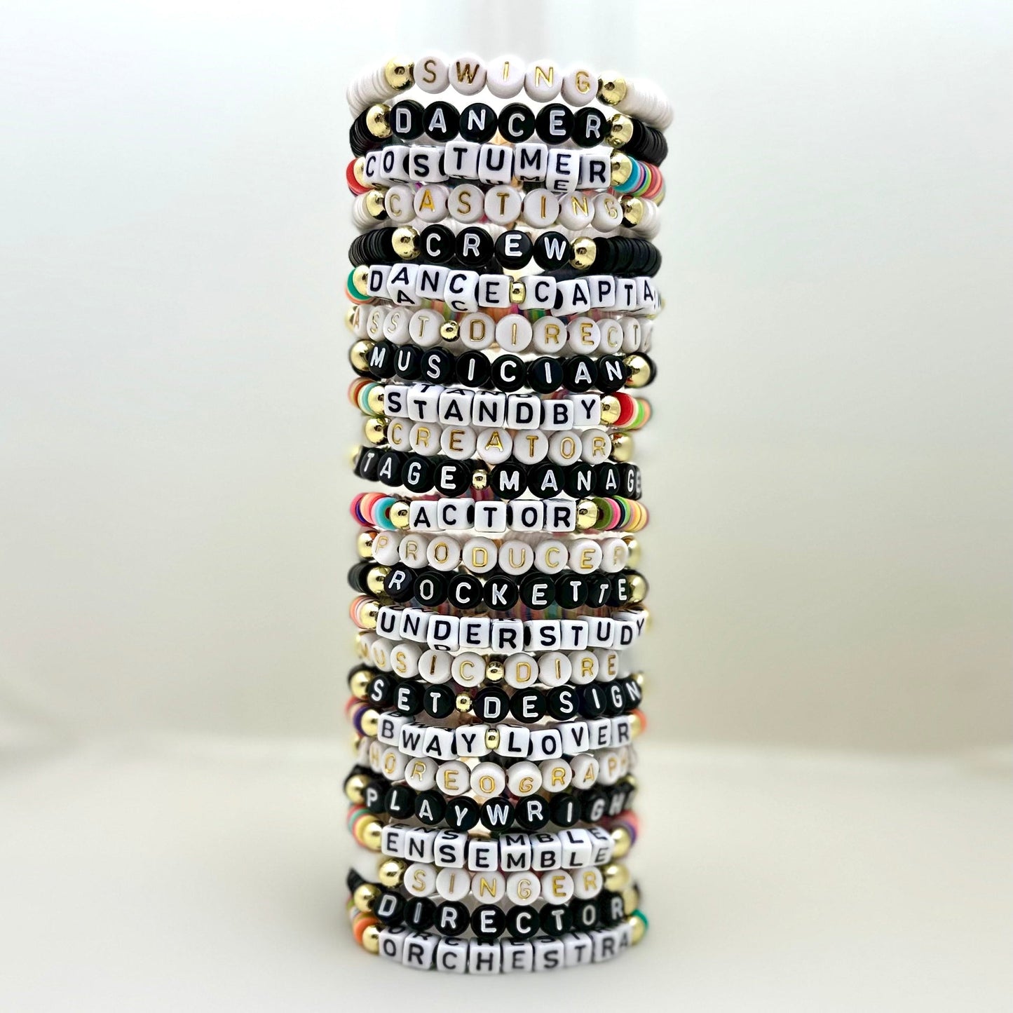 Broadway Stacks SPOTLIGHT Collection. Handcrafted beaded elastic-stretch bracelet with letter beads. Available in many varieties of theatre positions like actor, singer, dancer, director, stage manager, understudy, bway lover, crew, musician, etc. Gold color accents. Available in black, white and mulit-color. Broadway Stacks gold star logo bead on back.