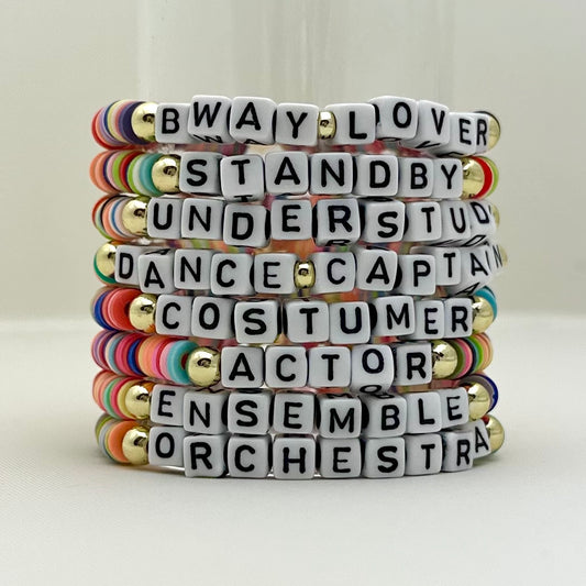 Broadway Stacks SPOTLIGHT Collection. Handcrafted beaded elastic-stretch bracelet with letter beads. Available in many varieties of theatre positions like actor, singer, dancer, director, stage manager, understudy, bway lover, crew, musician, etc. Gold color accents. Available in black, white and mulit-color. Broadway Stacks gold star logo bead on back.