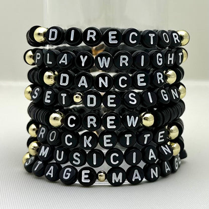 Broadway Stacks SPOTLIGHT Collection. Handcrafted beaded elastic-stretch bracelet with letter beads. Available in many varieties of theatre positions like actor, singer, dancer, director, stage manager, understudy, bway lover, crew, musician, etc. Gold color accents. Available in black, white and mulit-color. Broadway Stacks gold star logo bead on back.