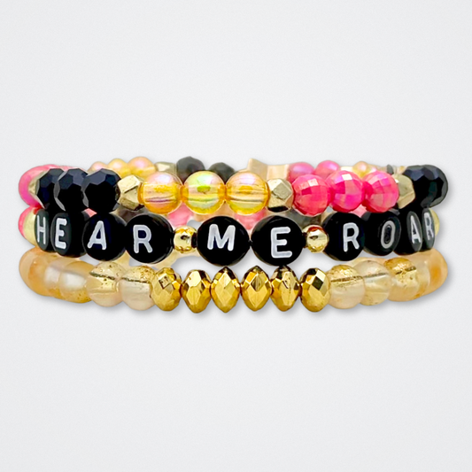 Broadway Stacks De Bois Band collection. 3 stretch bracelets included in Stack. Pinks, golds and black colored beads. Letter beads that spell quotes. Broadway Stacks gold star logo bead to remind you that you shine. & Juliet fans.