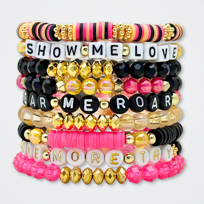 Broadway Stacks De Bois Band collection. 3 stretch bracelets included in Stack. Pinks, golds and black colored beads. Letter beads that spell quotes. Broadway Stacks gold star logo bead to remind you that you shine. & Juliet fans.