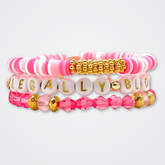 Broadway Stacks KEEP IT POSITIVE Collection. 9 stretch bracelets included in Stack. Pinks, white and gold colored beads. Letter beads that spell quotes. Gold star logo bead to remind you that you shine. Legally Blonde fans. 