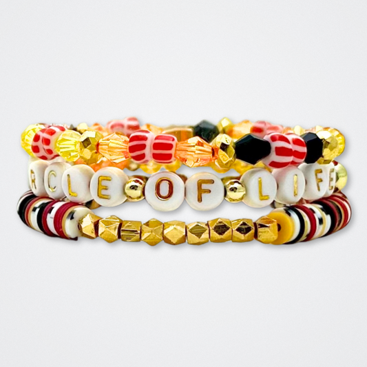 Broadway Stacks SAFARI collection. 3 stretch bracelets included in Stack. Dark reds, yellow, orange, white, black and gold colored beads. Animal print beads as well. Letter beads that spell quotes, Gold star logo bead to remind you that you shine.