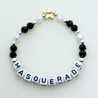 Broadway Stacks MASQUERADE Collection. 4 stretch bracelets included in Stack. Black, white and silver colored beads. Letter beads that spell quotes. Gold star logo bead to remind you that you shine. Phantom of the Opera and Masquerade NYC fans.