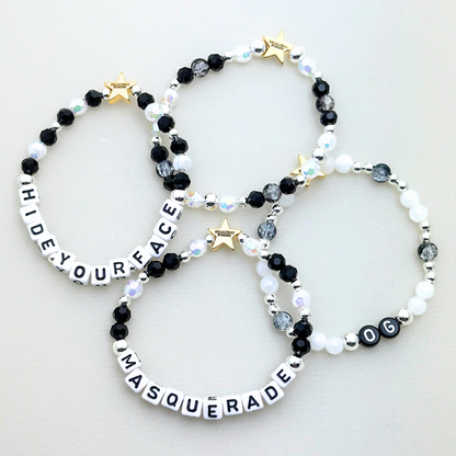 Broadway Stacks MASQUERADE Collection. 4 stretch bracelets included in Stack. Black, white and silver colored beads. Letter beads that spell quotes. Gold star logo bead to remind you that you shine. Phantom of the Opera and Masquerade NYC fans.