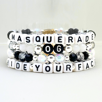 Broadway Stacks MASQUERADE Collection. 4 stretch bracelets included in Stack. Black, white and silver colored beads. Letter beads that spell quotes. Gold star logo bead to remind you that you shine. Phantom of the Opera and Masquerade NYC fans.