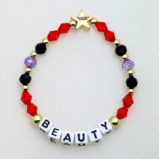 Broadway Stacks RED LIGHT Collection. 5 stretch bracelets included in Stack. Red, purple, black and gold colored beads. Letter beads that spell quotes. Gold star logo bead to remind you that you shine. Moulin Rouge fans. 