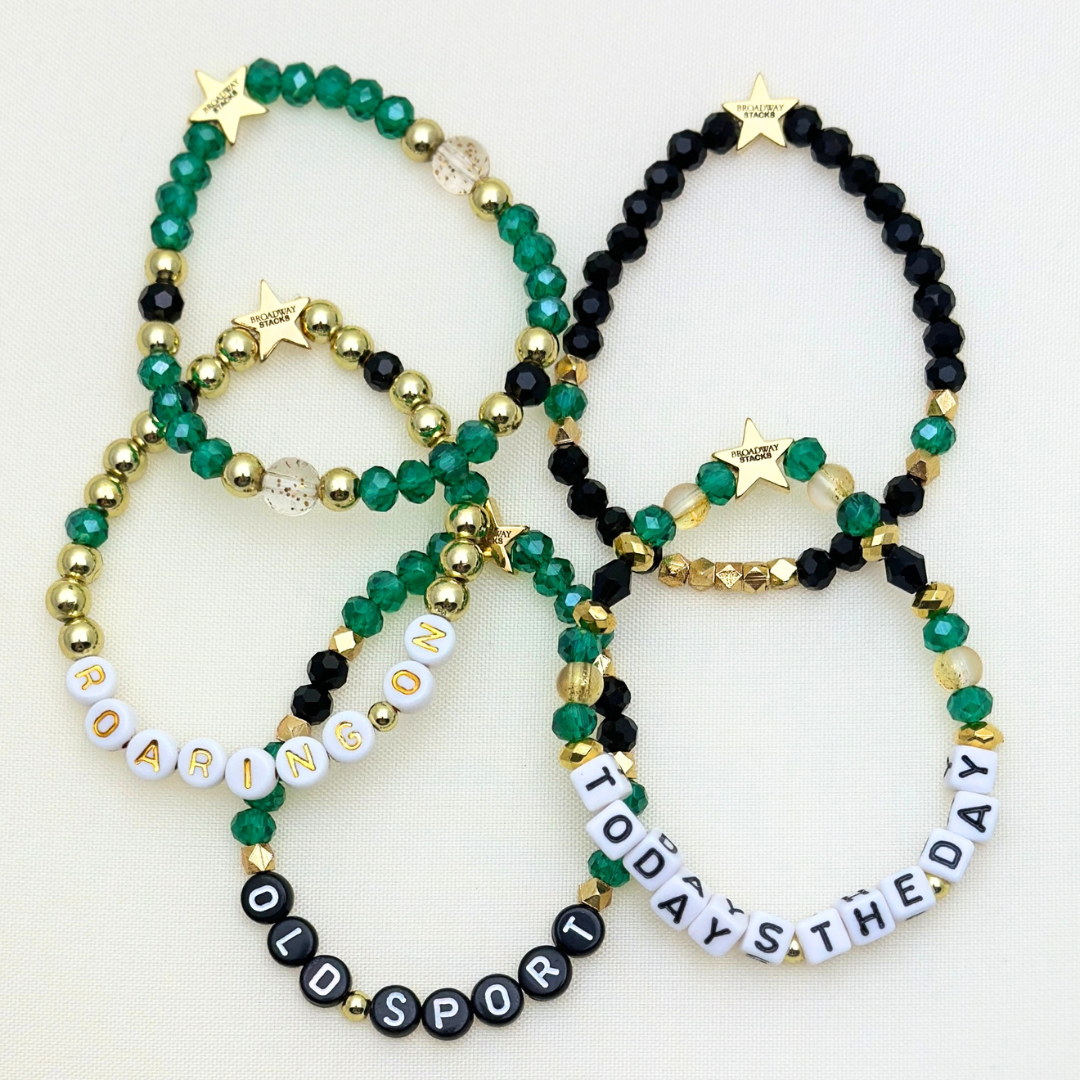 Broadway Stacks NEW MONEY Collection. 5 stretch bracelets included in Stack. Teal, black and gold colored beads. Letter beads that spell quotes. Gold star logo bead to remind you that you shine.