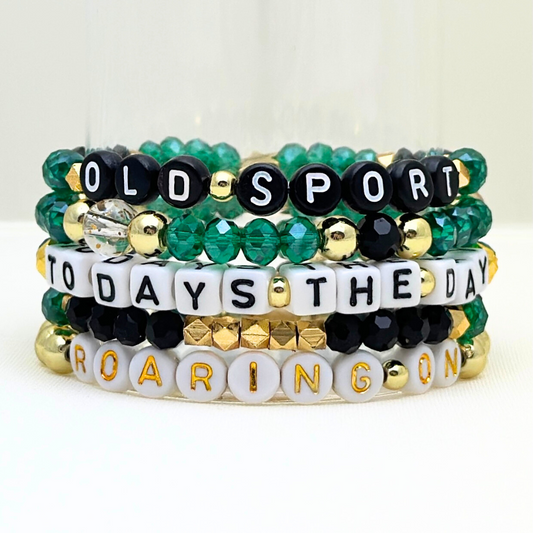 Broadway Stacks NEW MONEY Collection. 5 stretch bracelets included in Stack. Teal, black and gold colored beads. Letter beads that spell quotes. Gold star logo bead to remind you that you shine.